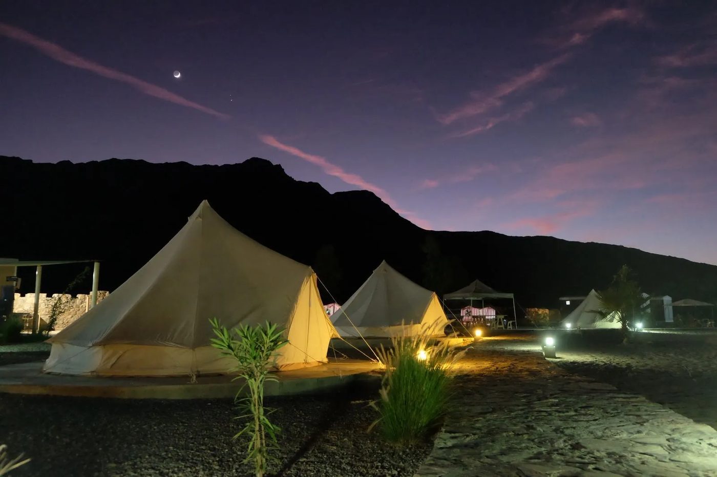 Jebel Sifah — beach tents under the mountains at night