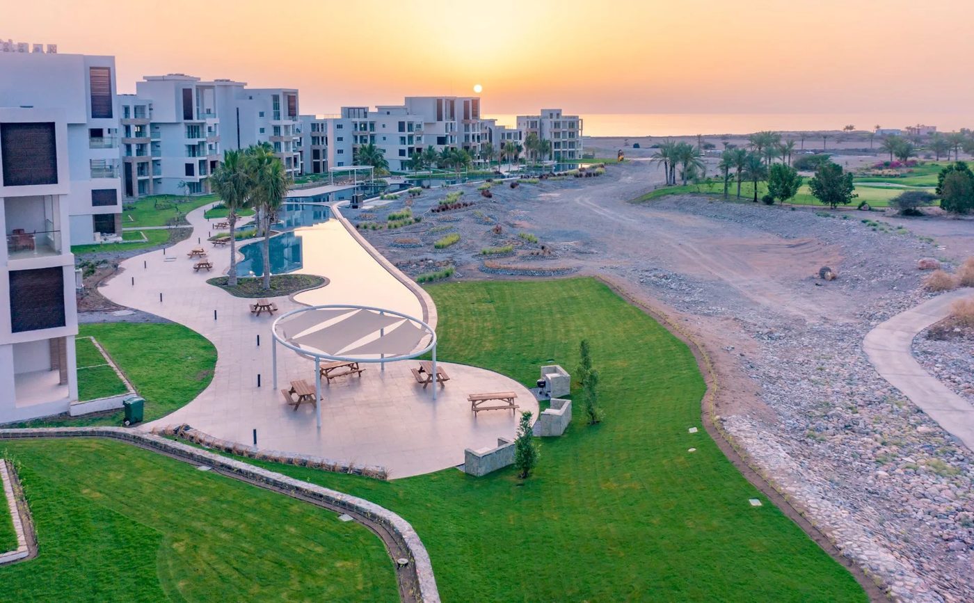 Jebel Sifah — residential area and lawns at sunset